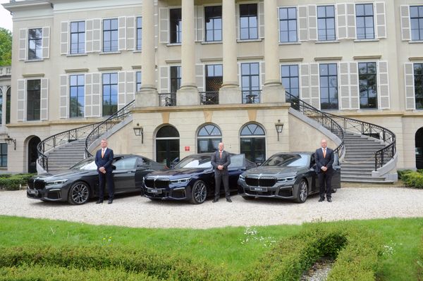 Drie ChauffeurPRO-chauffeurs bij hun wagens voor een landhuis